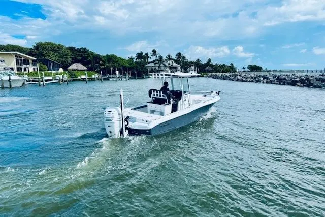 Slide: The Image of 2021 Crevalle 26 HCO boat cruising on a scenic waterway under a partly cloudy sky. - 4