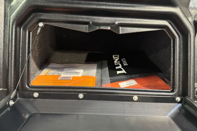 Slide: The Image of Storage compartment of 2026 Lund 1975 Tyee boat with manuals and documents. - 21