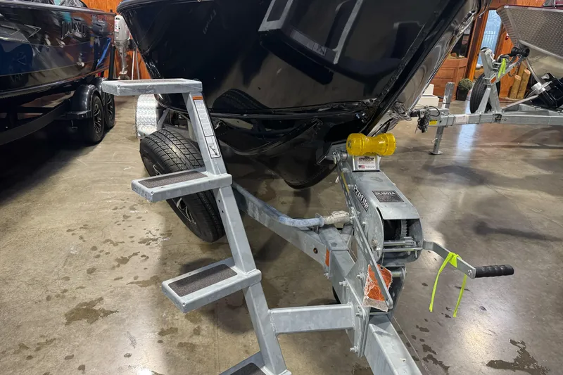 Slide: The Image of 2026 Lund 1975 Tyee boat on trailer with metal steps in a showroom. - 3