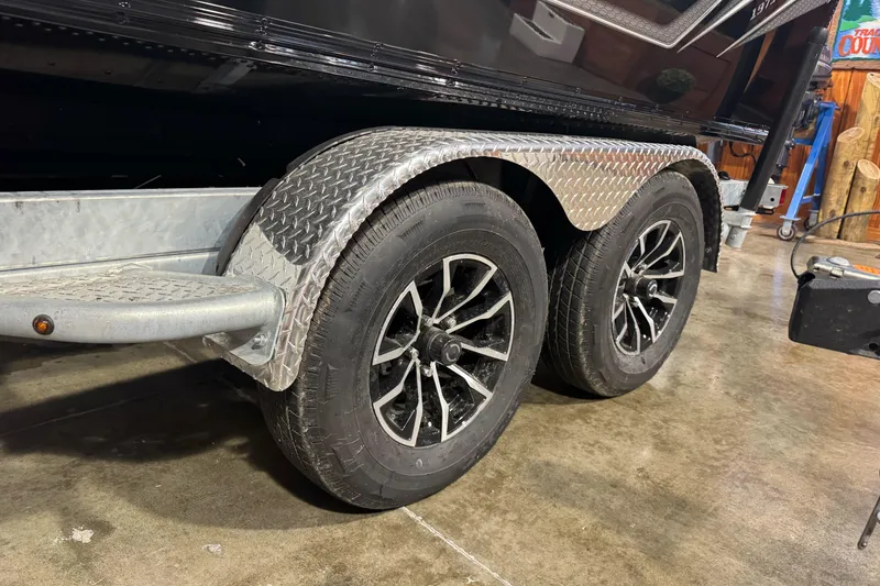 Slide: The Image of Trailer wheels of a 2026 Lund 1975 Tyee boat, featuring diamond plate fenders. - 5