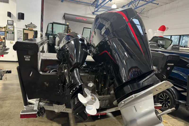 Slide: The Image of 2026 Lund 1975 Tyee boat with powerful outboard motors in showroom. - 7