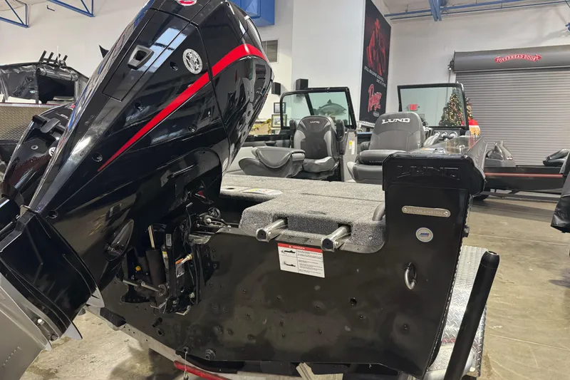 Slide: The Image of 2026 Lund 1975 Tyee boat with powerful outboard motor in showroom setting. - 8