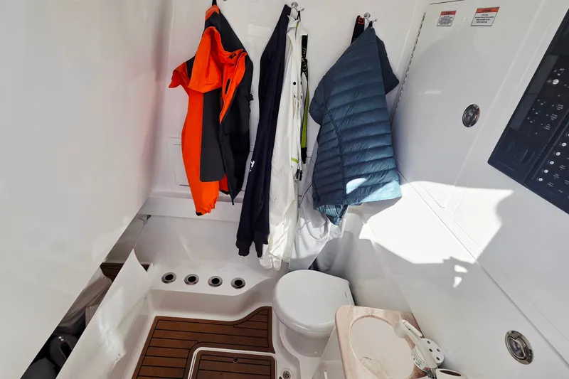 Slide: The Image of 2024 Valhalla Boatworks V-41 interior cabin with coats, toilet, and control panel. - 26