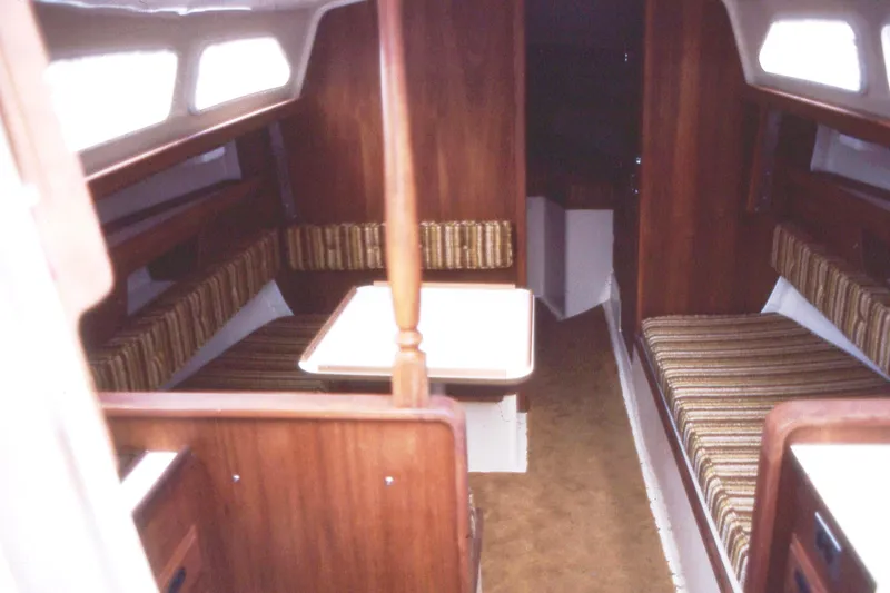 Slide: The Image of Interior of a 1975 Ranger Yachts 33, featuring wood paneling and striped seating. - 2