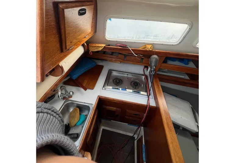 Slide: The Image of 1975 Ranger Yachts 33 interior with wooden cabinetry and compact kitchen area. - 3