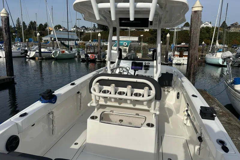 Slide: The Image of 2023 Bayliner Trophy T24CC boat docked at a marina, showcasing its spacious deck and modern design. - 12