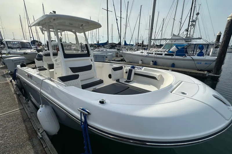 Slide: The Image of 2023 Bayliner Trophy T24CC boat docked at marina, showcasing sleek design and spacious seating. - 17