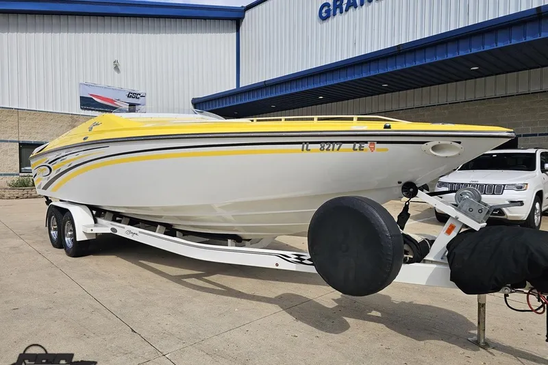 Slide: The Image of 2007 Baja 26 Outlaw boat with yellow accents on a trailer, parked outside a building. - 14