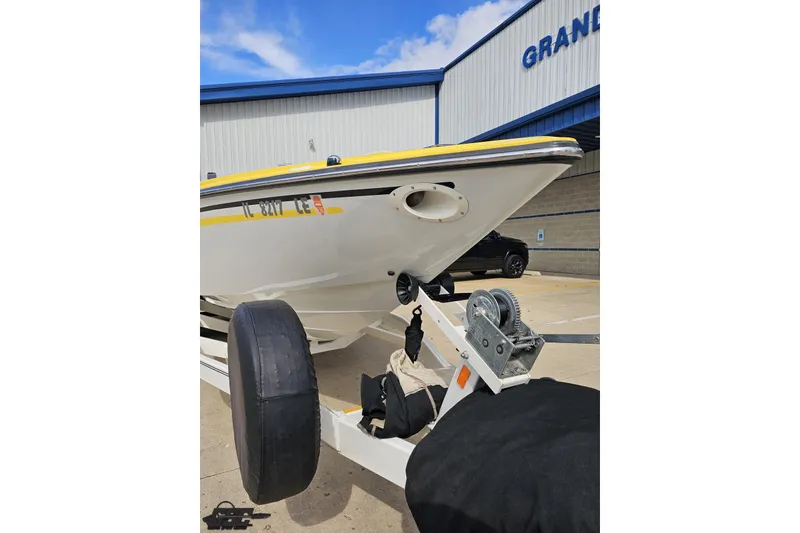 Slide: The Image of 2007 Baja 26 Outlaw boat on trailer, parked outside a building under a blue sky. - 15