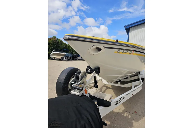 Slide: The Image of 2007 Baja 26 Outlaw boat on trailer, parked outdoors under a blue sky. - 17