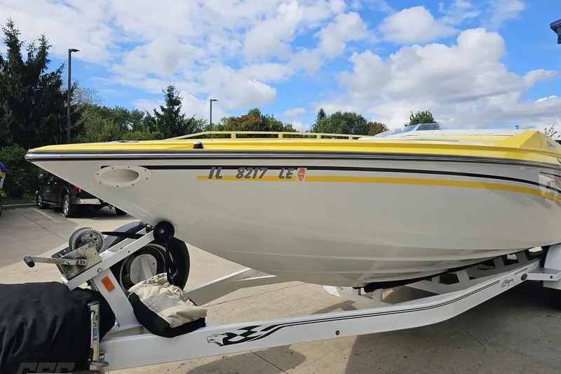 Slide: The Image of 2007 Baja 26 Outlaw boat on trailer, yellow and white design, parked outdoors. - 18