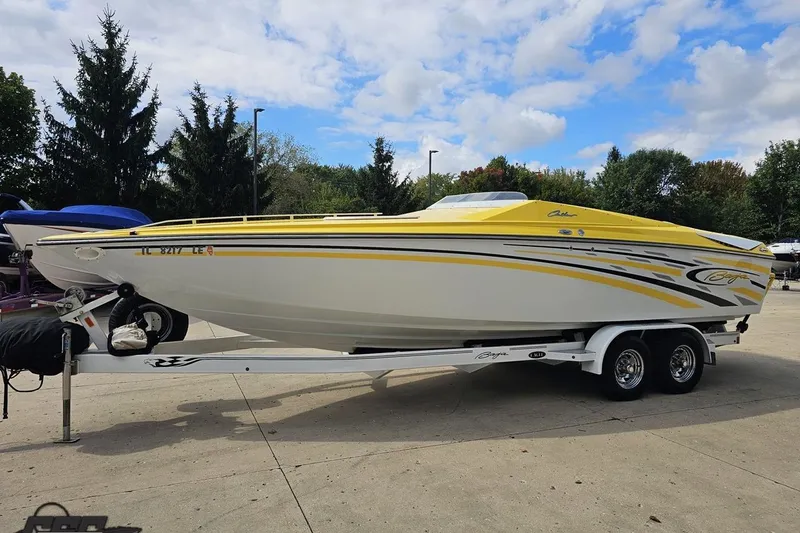 Slide: The Image of 2007 Baja 26 Outlaw speedboat with yellow accents on a trailer, parked outdoors. - 20