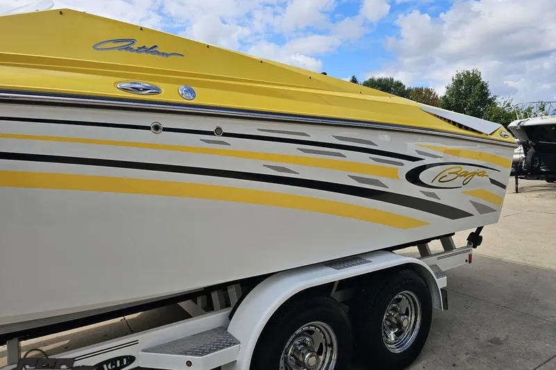 Slide: The Image of 2007 Baja 26 Outlaw boat with yellow and white design on a trailer. - 25