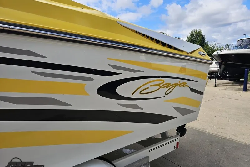 Slide: The Image of 2007 Baja 26 Outlaw boat with yellow and black graphics on a trailer. - 26
