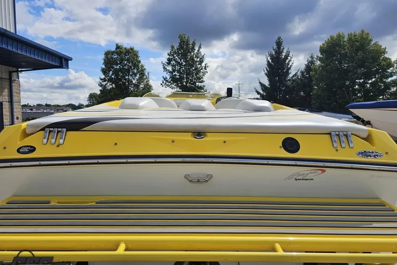 Slide: The Image of 2007 Baja 26 Outlaw boat, yellow exterior, parked outdoors under cloudy sky. - 33