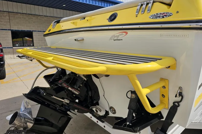 Slide: The Image of 2007 Baja 26 Outlaw boat with yellow accents and MerCruiser engine, docked outdoors. - 35