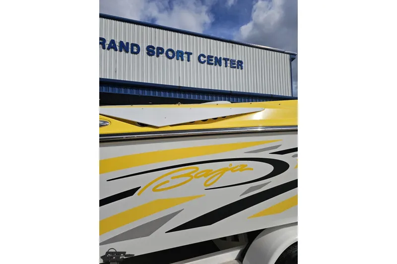 Slide: The Image of 2007 Baja 26 Outlaw boat with vibrant yellow graphics at Grand Sport Center. - 36