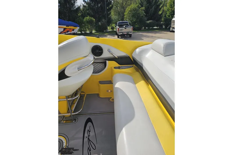 Slide: The Image of 2007 Baja 26 Outlaw boat interior with yellow and white seating, parked outdoors. - 52