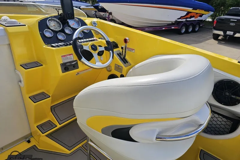 Slide: The Image of 2007 Baja 26 Outlaw boat cockpit with yellow dashboard and white seating. - 55