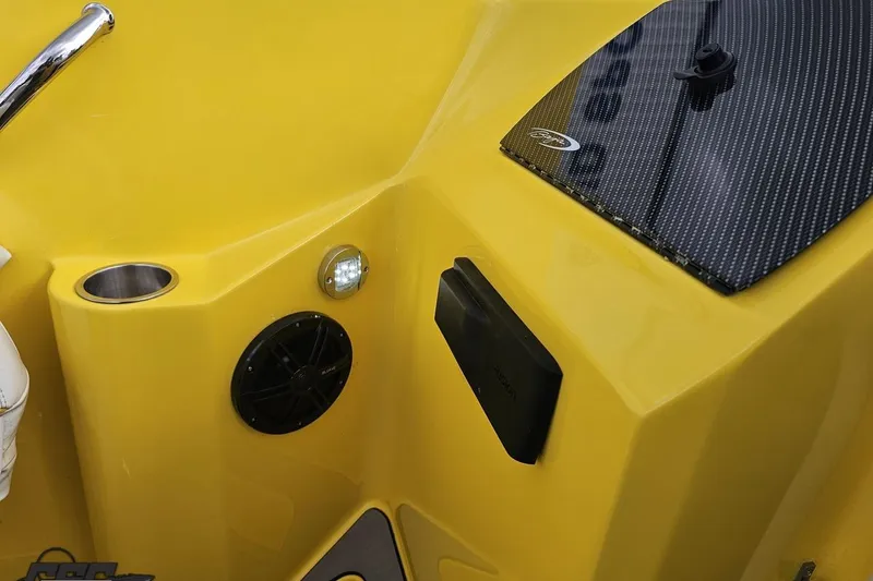 Slide: The Image of Yellow 2007 Baja 26 Outlaw boat interior with speaker, cup holder, and carbon fiber panel. - 64