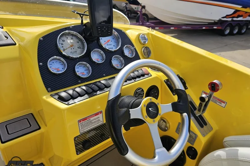 Slide: The Image of 2007 Baja 26 Outlaw boat dashboard with yellow accents and steering wheel. - 66