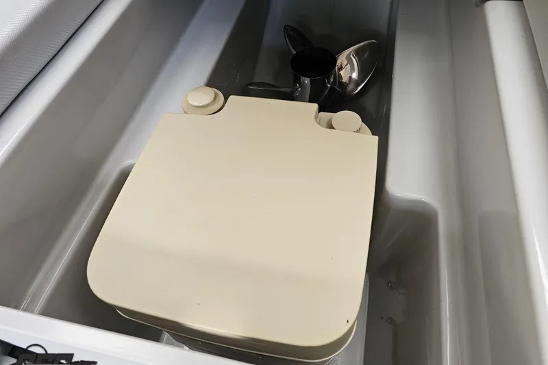 Slide: The Image of 2007 Baja 26 Outlaw boat compartment with propeller and beige cover. - 82