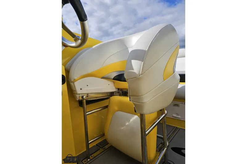 Slide: The Image of 2007 Baja 26 Outlaw boat seat with yellow and white upholstery under a cloudy sky. - 88