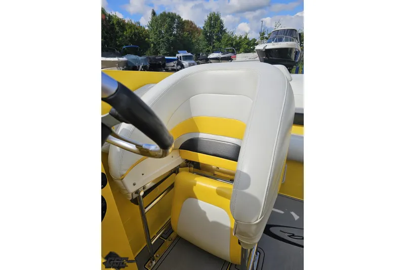 Slide: The Image of 2007 Baja 26 Outlaw boat cockpit with yellow and white seating, steering wheel visible. - 89