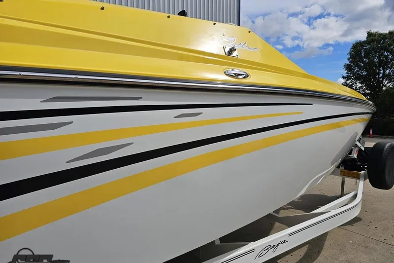 Slide: The Image of 2007 Baja 26 Outlaw boat with yellow and white design, parked on a trailer. - 9