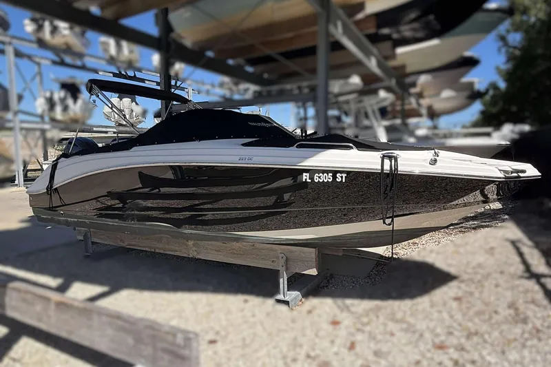 The Image of 2020 NauticStar 223 DC boat in storage, side view, with cover and registration number visible. - 0