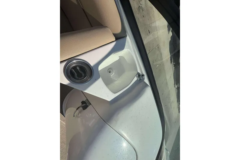 Slide: The Image of Interior view of a 2020 NauticStar 223 DC boat, featuring a cup holder and beige seating. - 19