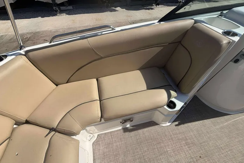 Slide: The Image of 2020 NauticStar 223 DC boat interior with beige seating and cup holders. - 20