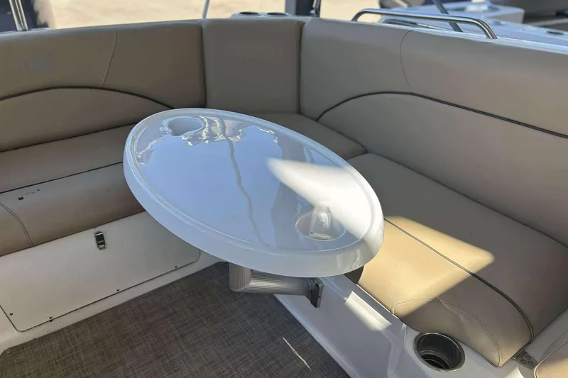 Slide: The Image of 2020 NauticStar 223 DC boat interior with beige seating and oval table. - 22