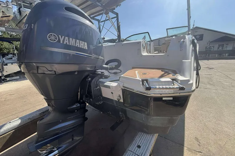 Slide: The Image of 2020 NauticStar 223 DC boat with Yamaha outboard motor, docked on a sunny day. - 25