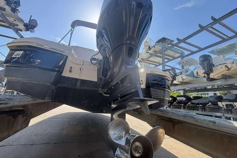 Slide: The Image of 2020 NauticStar 223 DC boat on a rack, showcasing its outboard motor and propeller. - 26