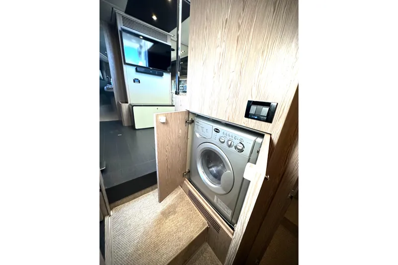 Slide: The Image of Laundry area inside 2019 Azimut Atlantis 51 yacht, featuring a built-in washing machine. - 25