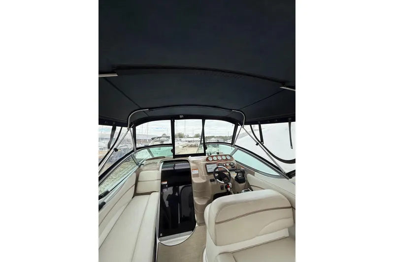 Slide: The Image of 2005 Larson Cabrio 290 boat interior with helm, seating, and dashboard controls. - 13