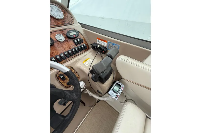 Slide: The Image of 2005 Larson Cabrio 290 boat dashboard with steering wheel and control panel. - 15