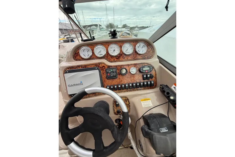 Slide: The Image of 2005 Larson Cabrio 290 boat dashboard with Garmin navigation and control gauges. - 16