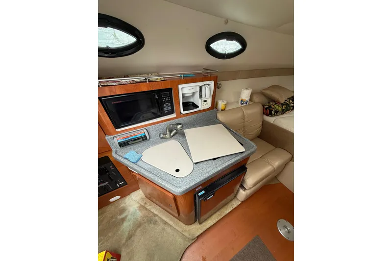Slide: The Image of 2005 Larson Cabrio 290 cabin interior with kitchenette and seating area. - 19