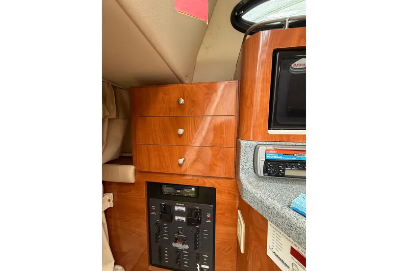 Slide: The Image of 2005 Larson Cabrio 290 interior with wooden cabinetry and control panel. - 23