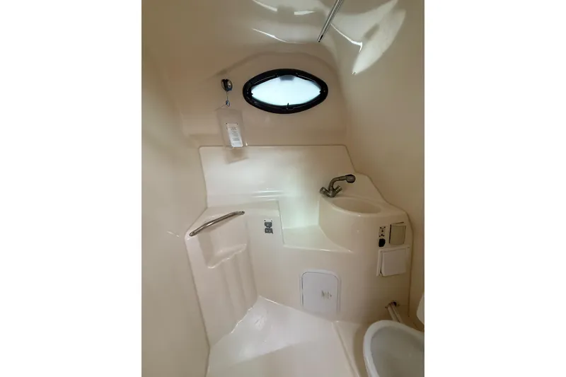 Slide: The Image of 2005 Larson Cabrio 290 boat bathroom with sink, porthole, and compact design. - 28