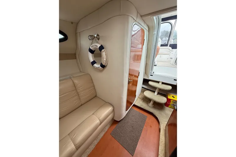 Slide: The Image of Interior of 2005 Larson Cabrio 290 boat with beige seating and nautical decor. - 30