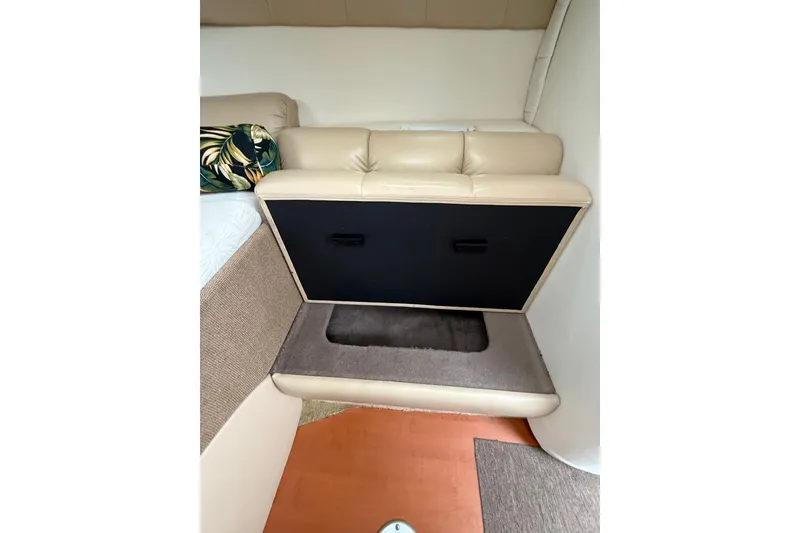 Slide: The Image of 2005 Larson Cabrio 290 interior with beige seating and storage compartment. - 36