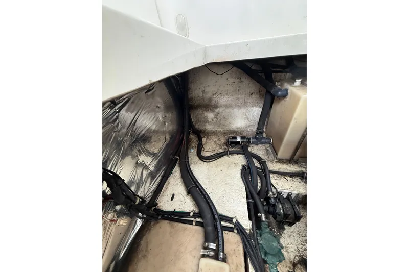 Slide: The Image of 2005 Larson Cabrio 290 engine compartment with hoses and wiring visible. - 48