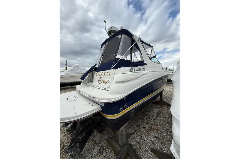 Slide: The Image of 2005 Larson Cabrio 290 boat on dry dock under cloudy skies. - 5