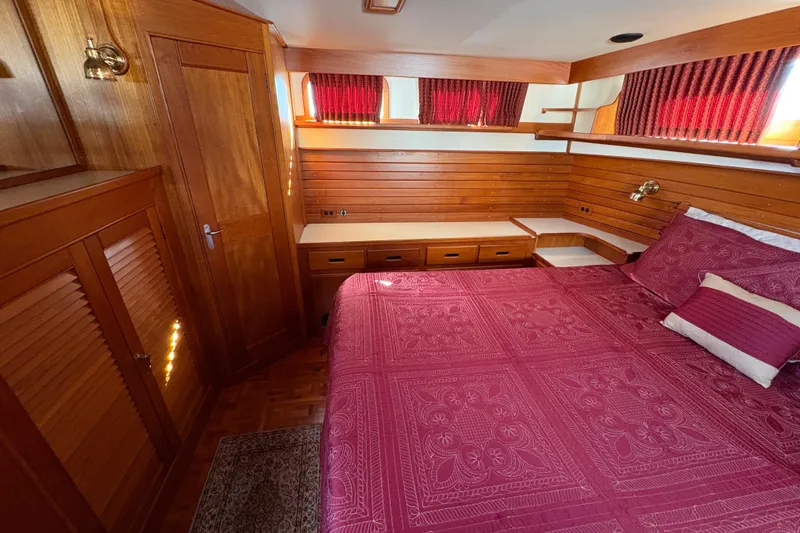 Slide: The Image of Cozy bedroom in 1995 Grand Banks 42 Motoryacht with wood paneling and red bedding. - 37
