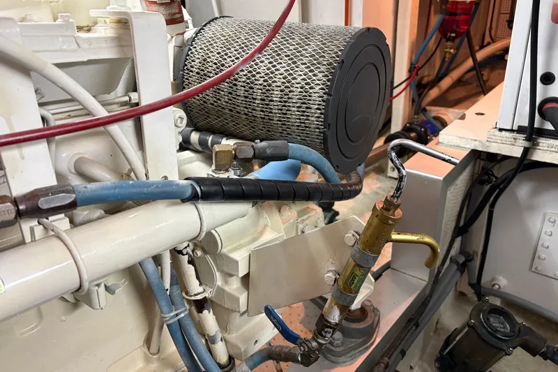 Slide: The Image of Engine room of 1995 Grand Banks 42 Motoryacht with visible air filter and hoses. - 47