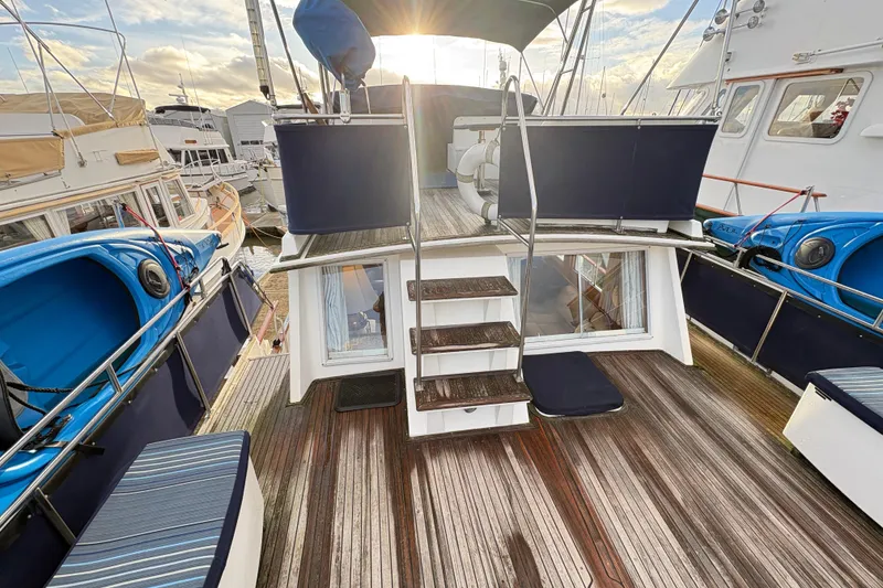 Slide: The Image of 1995 Grand Banks 42 Motoryacht deck with wooden flooring and blue accents. - 8