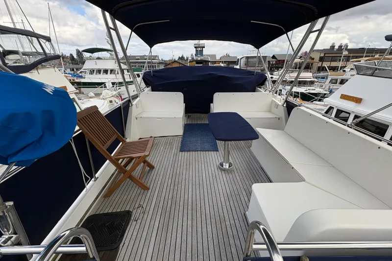Slide: The Image of 1995 Grand Banks 42 Motoryacht deck with seating, table, and marina view. - 9